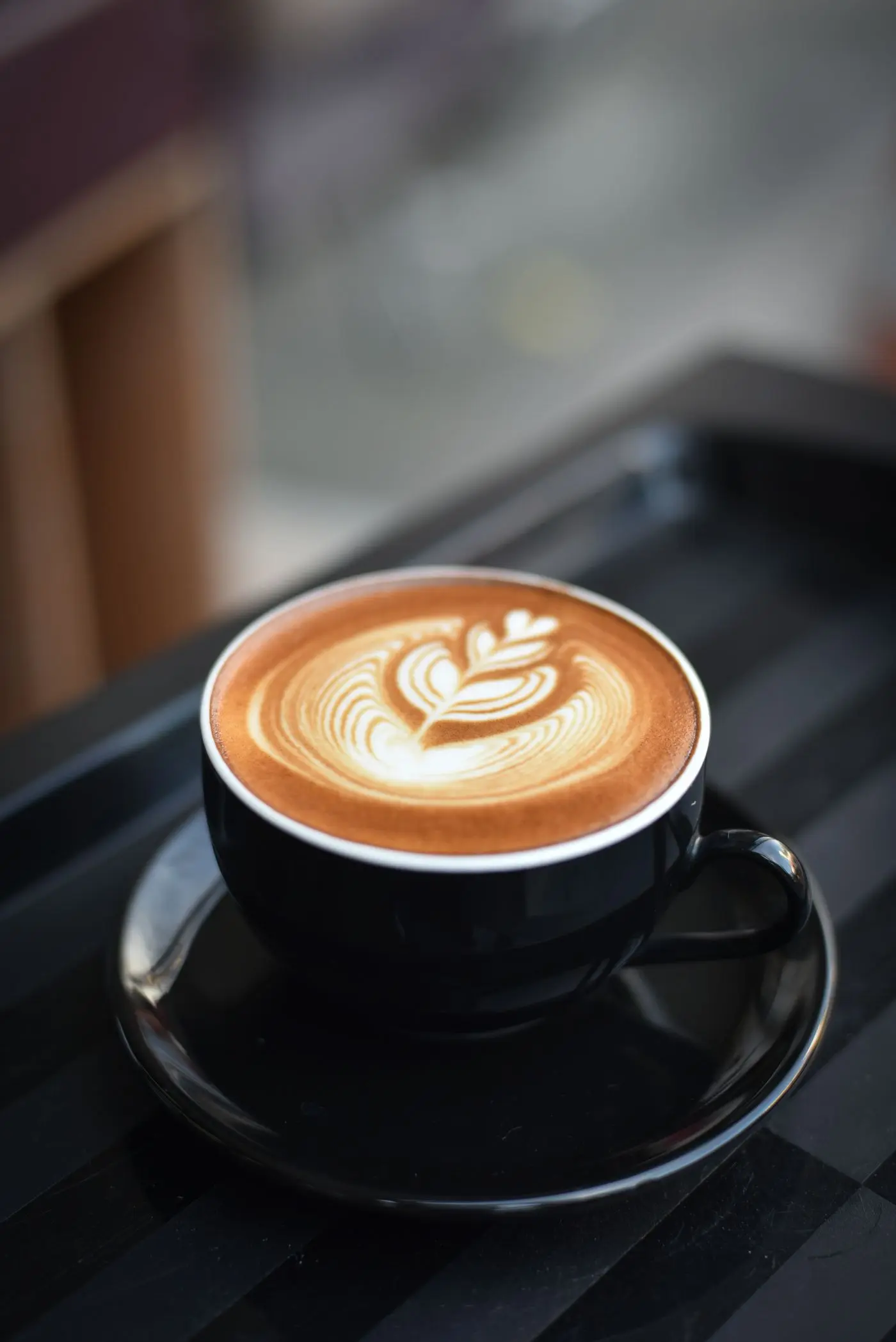 A latte in a black cup on a café counter